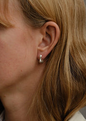 person wearing dunton ellerkamp jewelry Owen Huggies in Silver