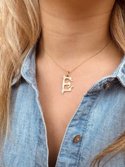 Person wearing The Moonstoned fine jewelry 14k yellow gold Diamond Initial Pendant