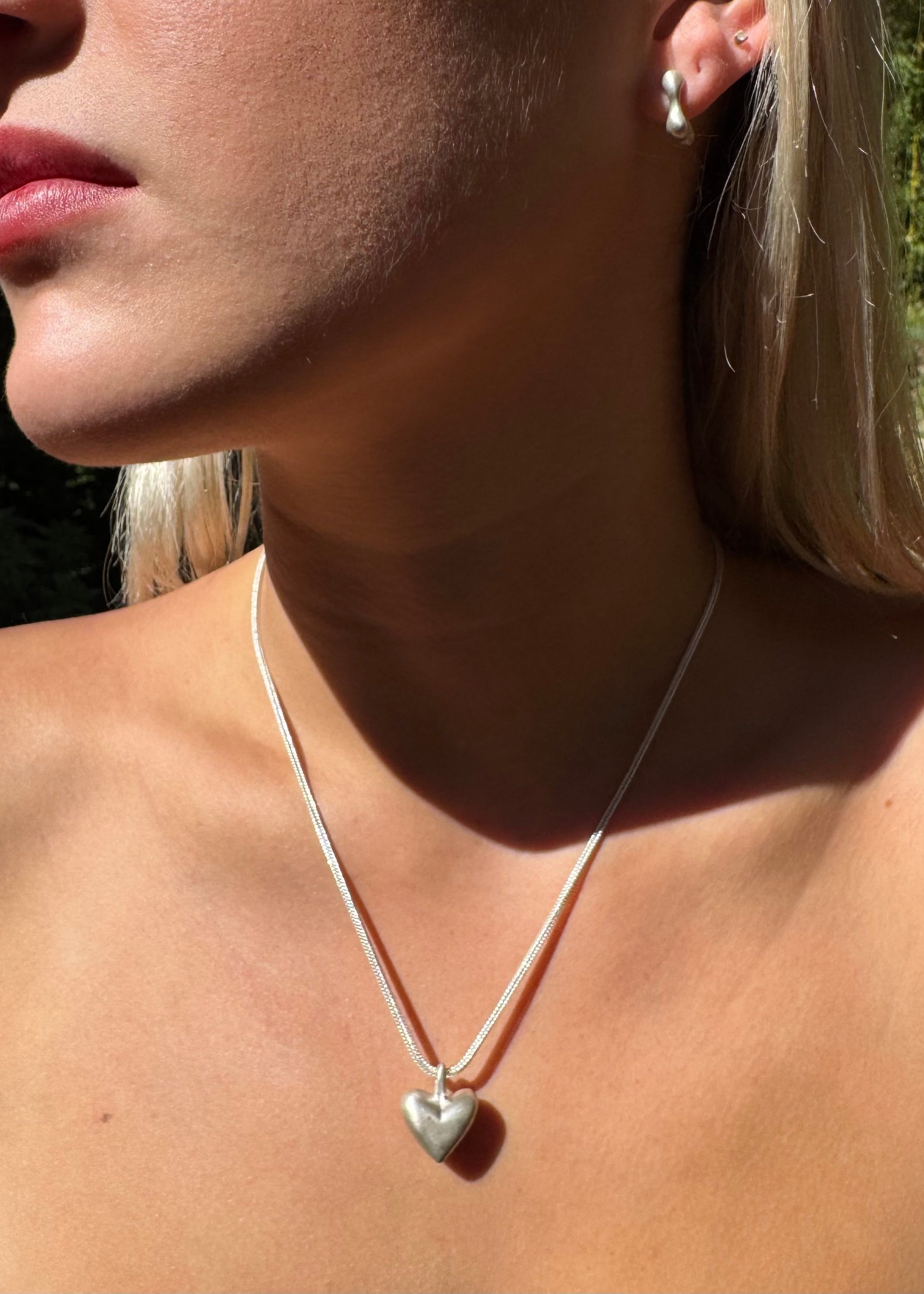 person wearing dunton ellerkamp jewelry American Folk Heart Pendant Necklace silver foxtail chain