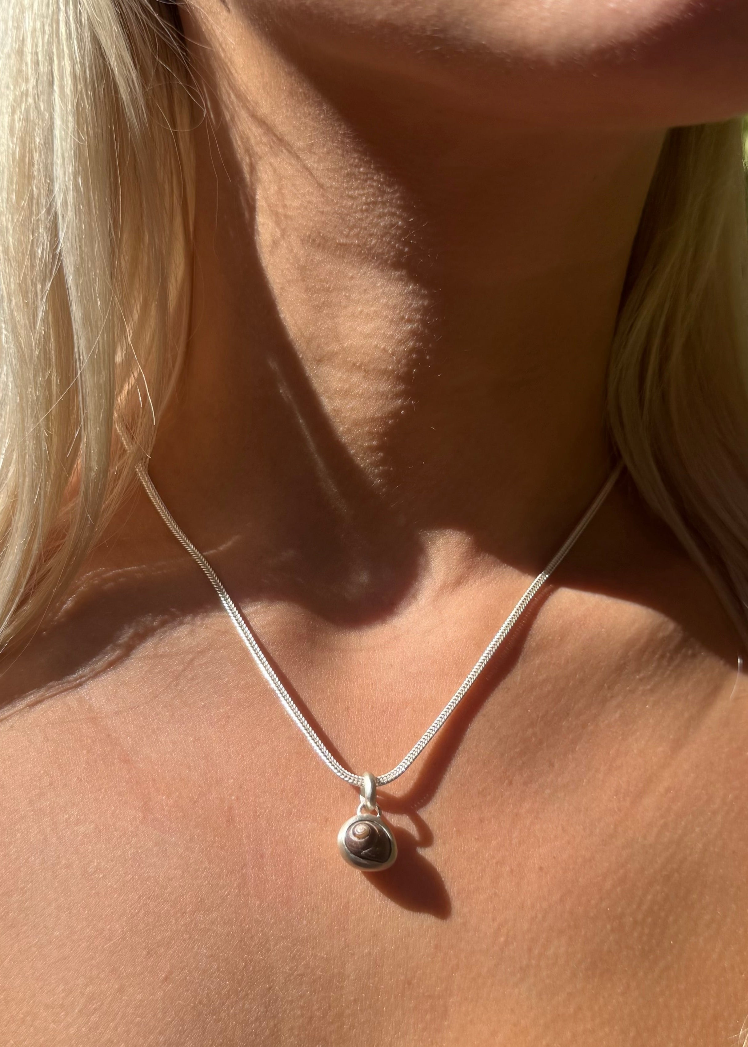 person wearing dunton ellerkamp jewelry One-of-a-Kind Snail Shell Pendant Necklace in Silver foxtail chain