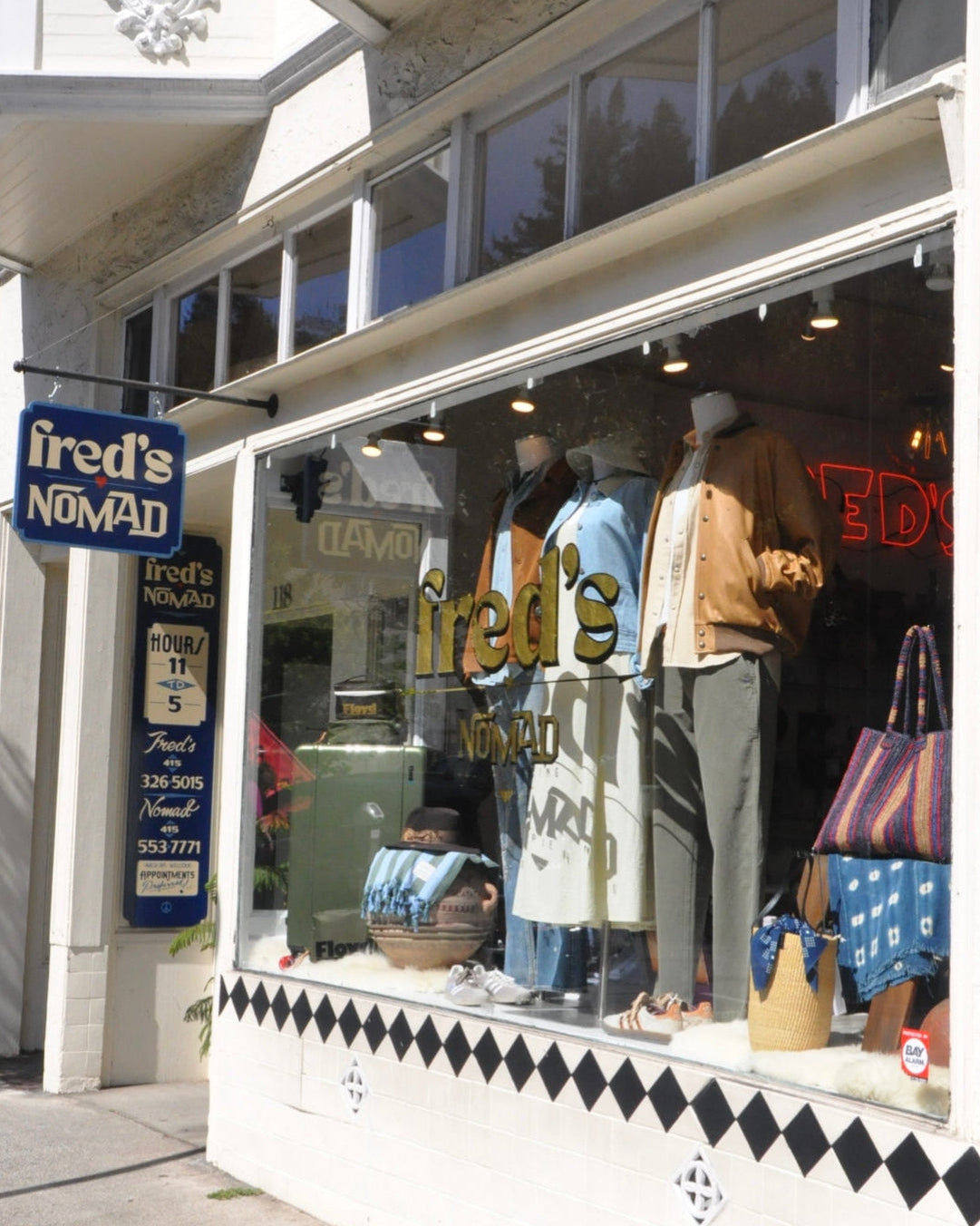 Storefront with 'fred's Nomad' sign and window display of clothing and bags