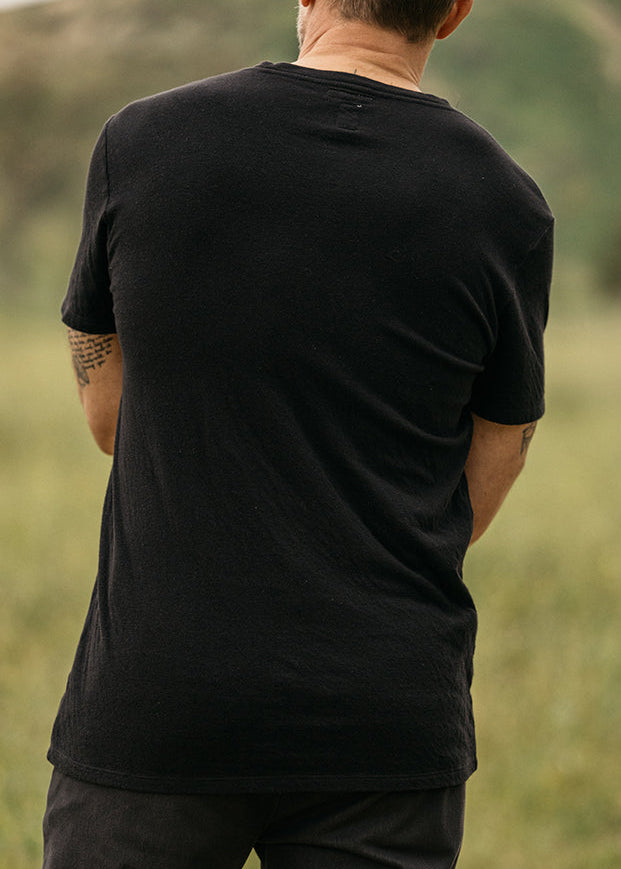 person wearing hiroshi kato mens The Stamp Double Knit Tee in Black