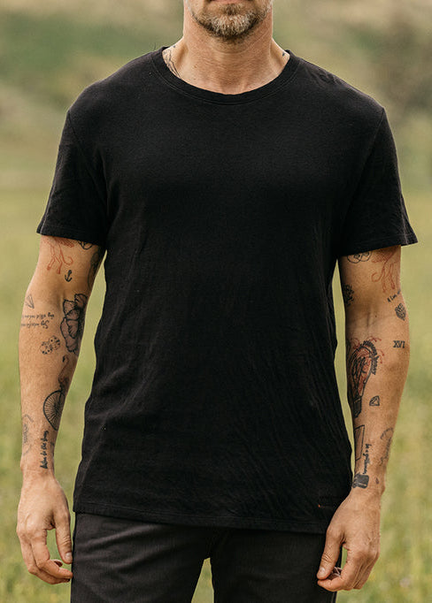 person wearing hiroshi kato mens The Stamp Double Knit Tee in Black