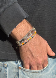 person wearing maor mens jewelry Neon Orange Pattern Malli Bracelet in Silver Off White Pattern Palli Bracelet in Silver Onyx Bead Percep Bracelet in Silver