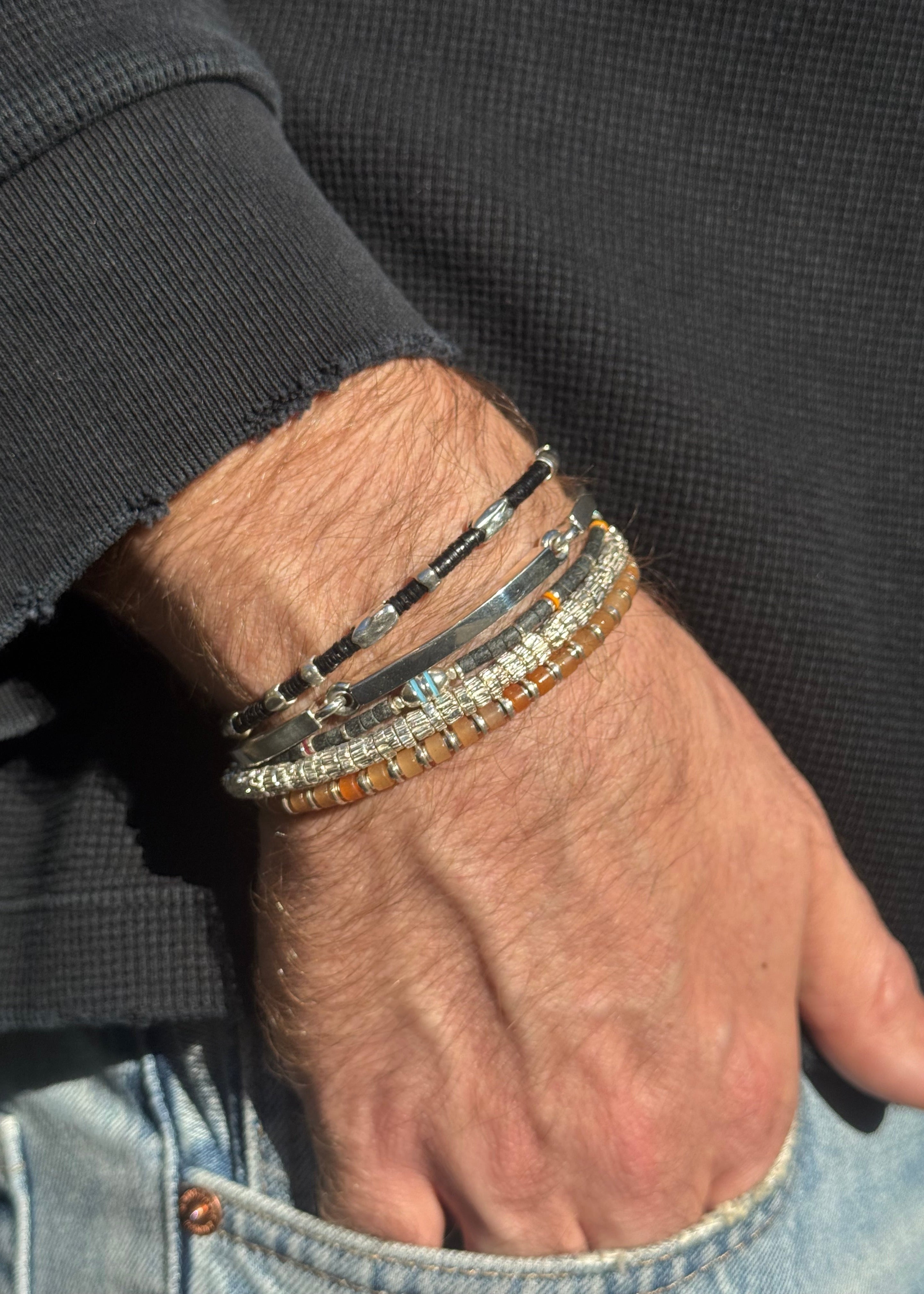 person wearing maor mens jewelry Orange Aventurine Sapet Bracelet in Silver Black Beaded Dryp Bracelet in Silver Black Jade Cherish Bracelet in Silver Perihelion Bracelet in Silver